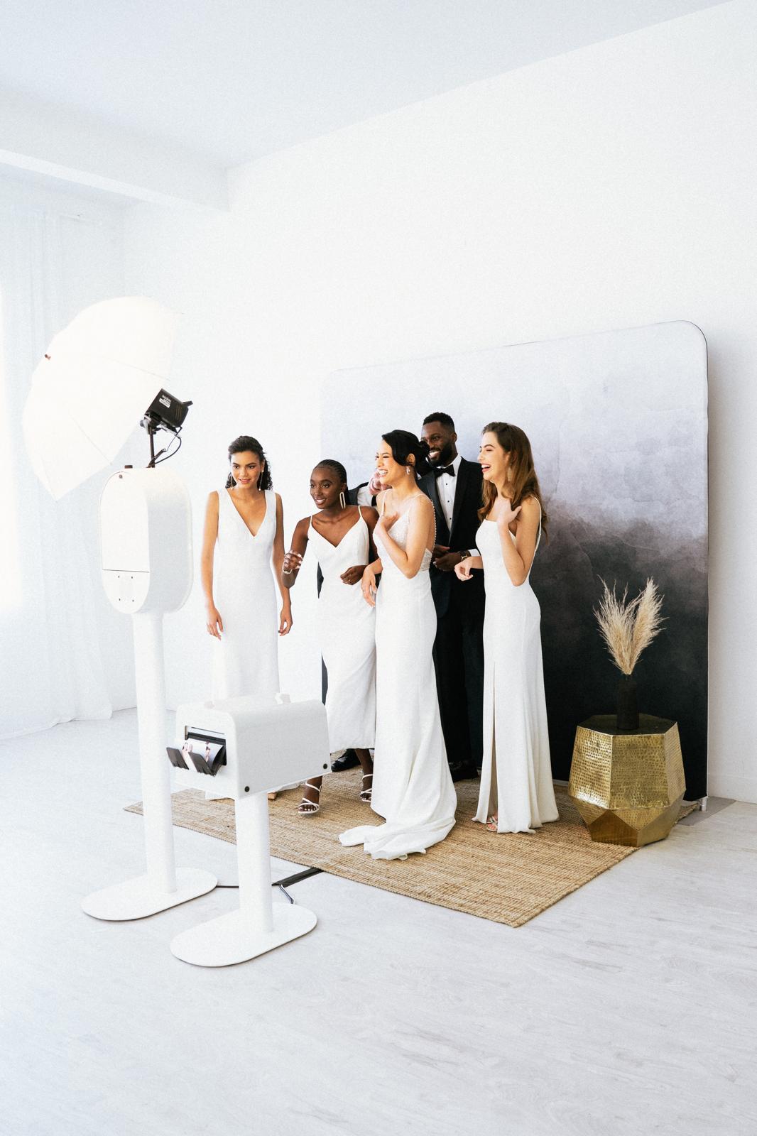 Bridal party laughing in front of The Flash Bar photobooth