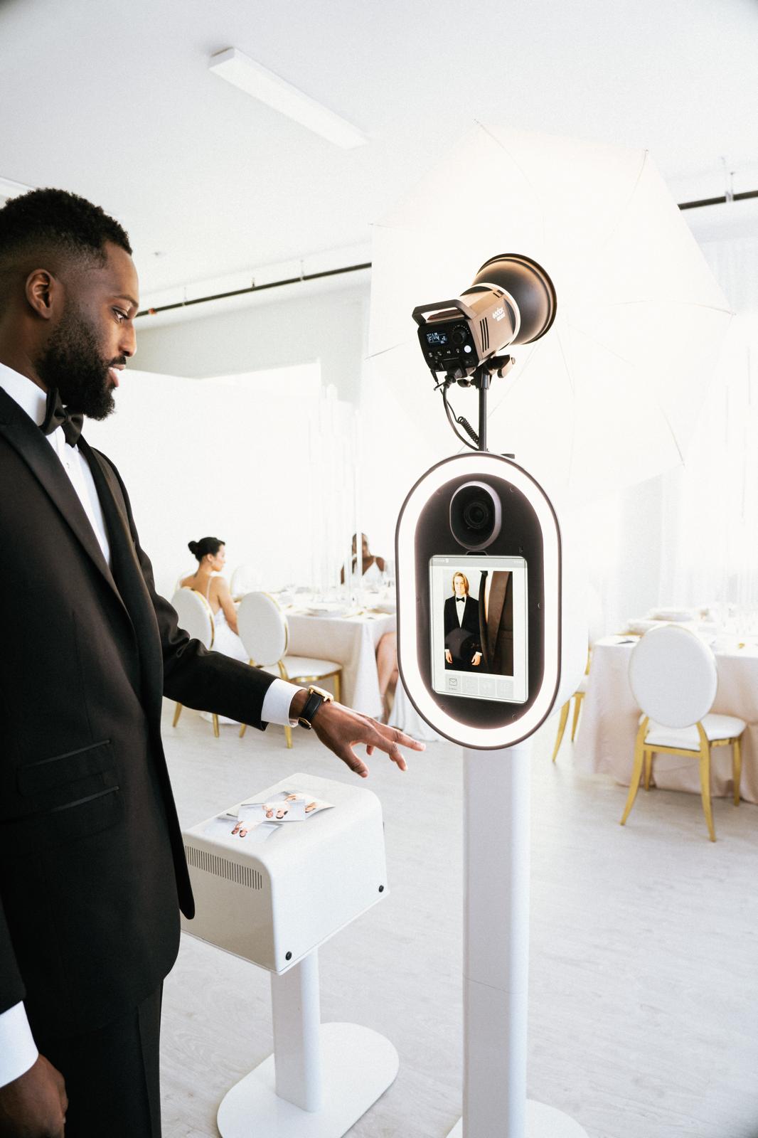 Groom picking up his printed photo strip from The Flash Bar photobooth